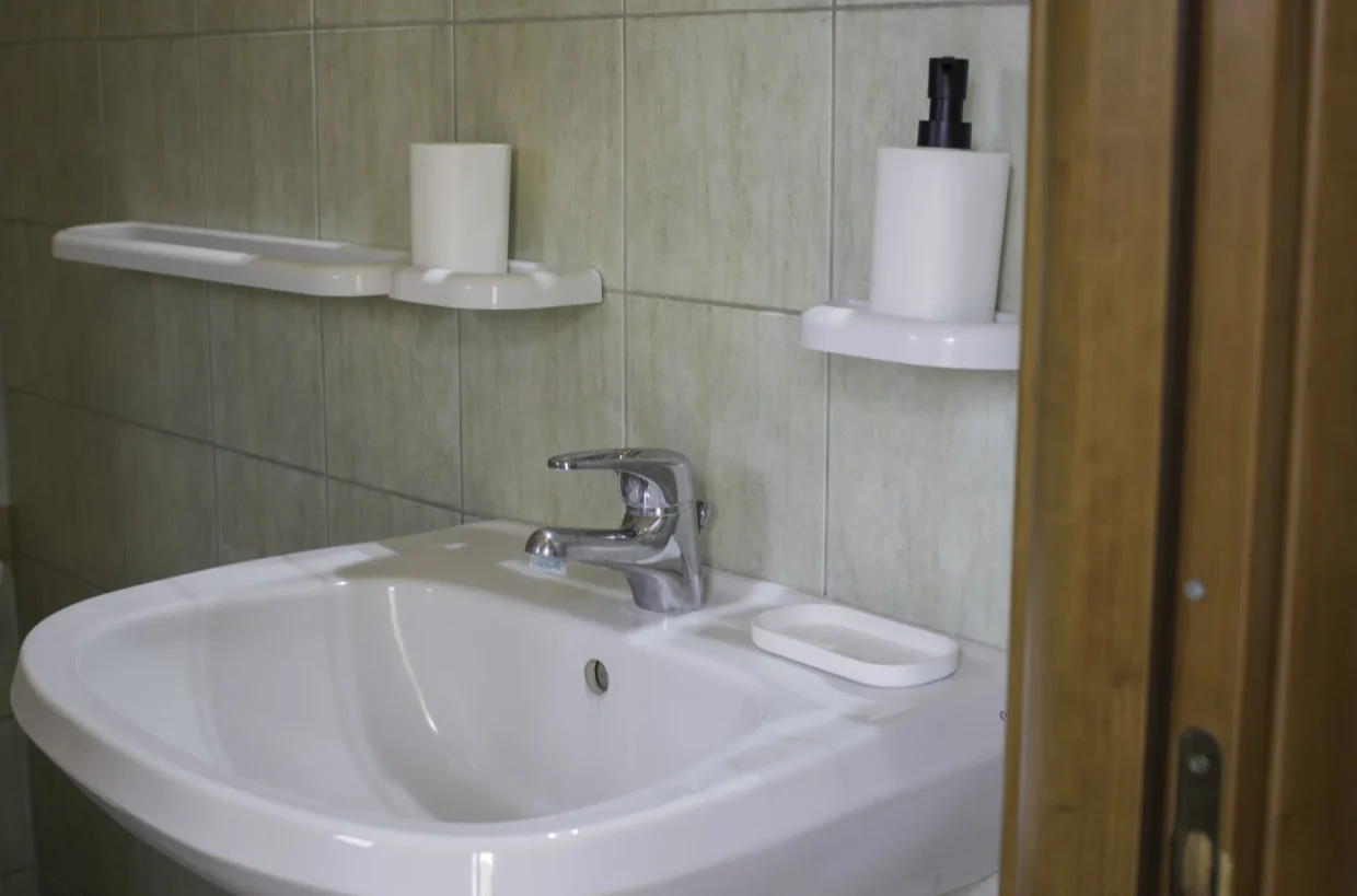 Bathroom washbasin, mirror and tiled wall.