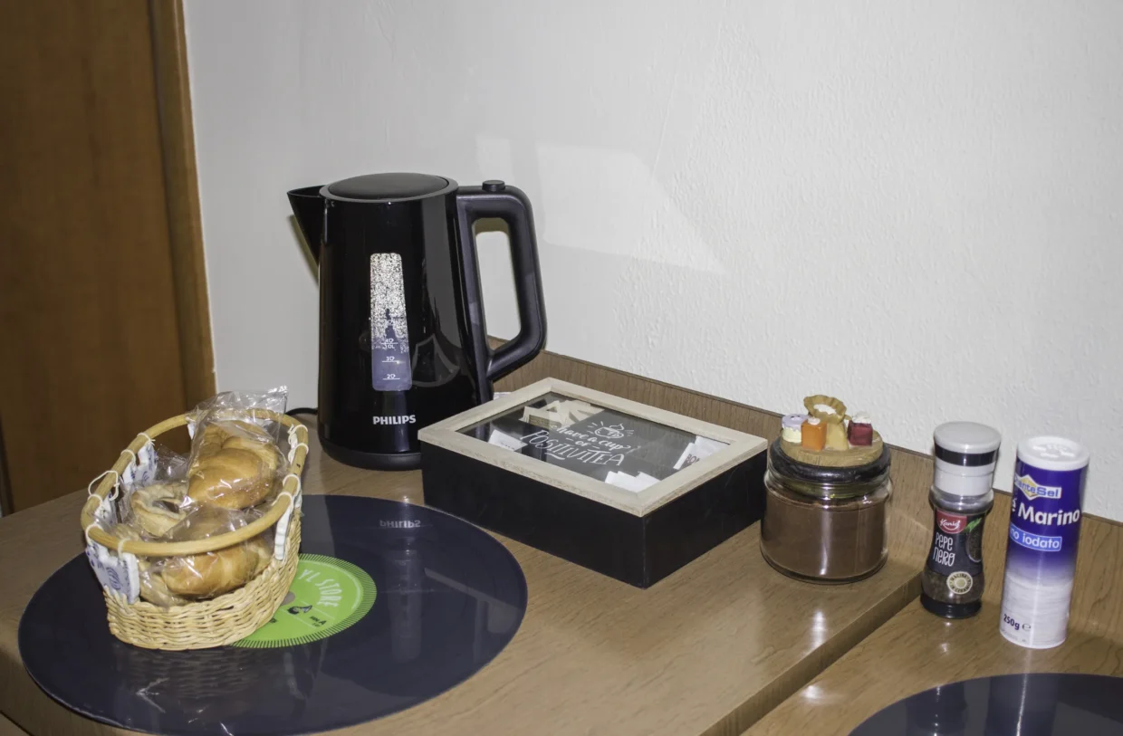 Kettle, tea tray and moka pot on a wooden surface.