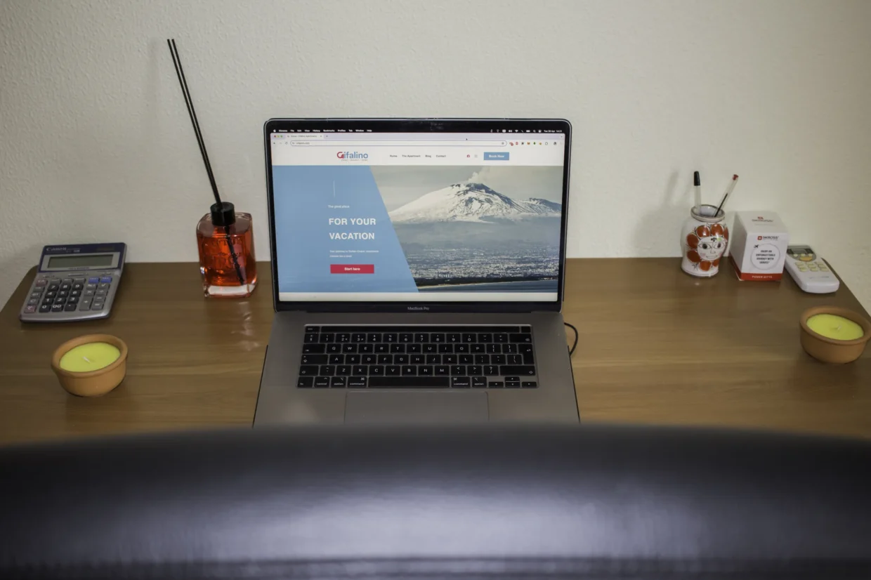 Desk with a laptop, telephone and lamp inside the apartment.